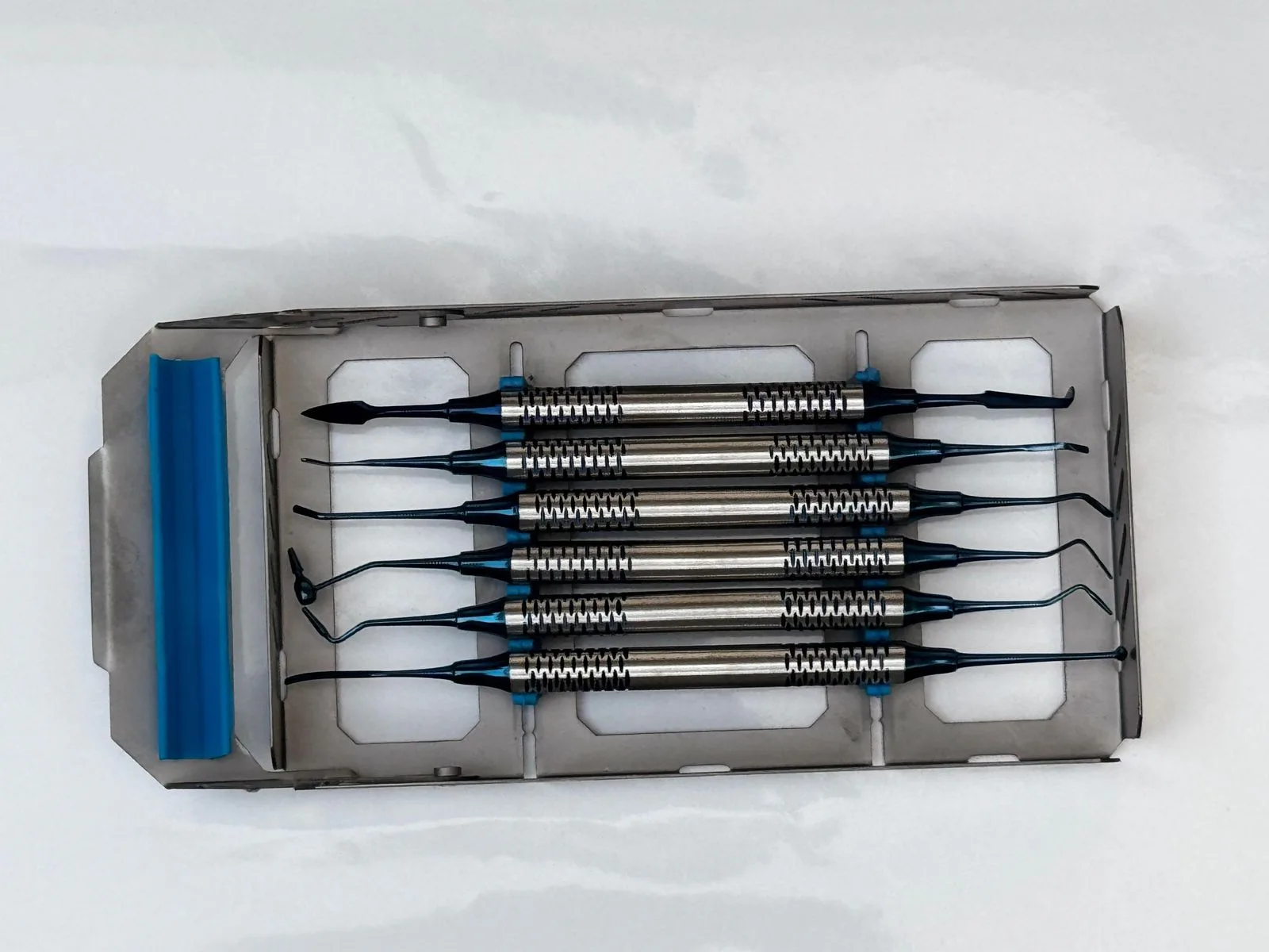 Six double-ended composite hand instruments in a blue-accented metal cassette — view 1